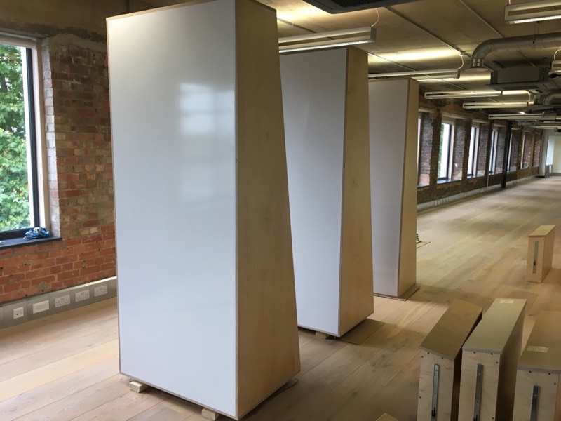 Several tall bookshelves with whiteboards on the back stand in the empty Firefly offices